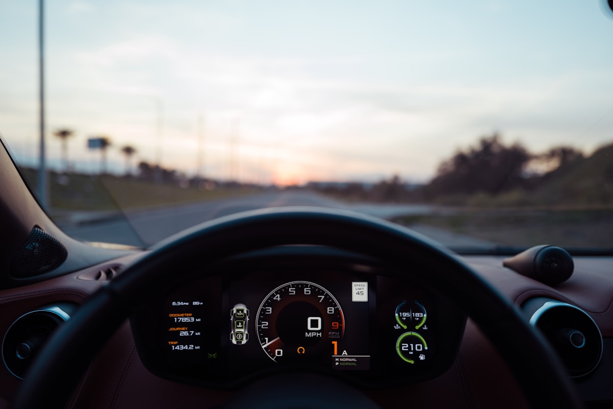 Painel de instrumentos de um carro mostrando o odômetro ao entardecer